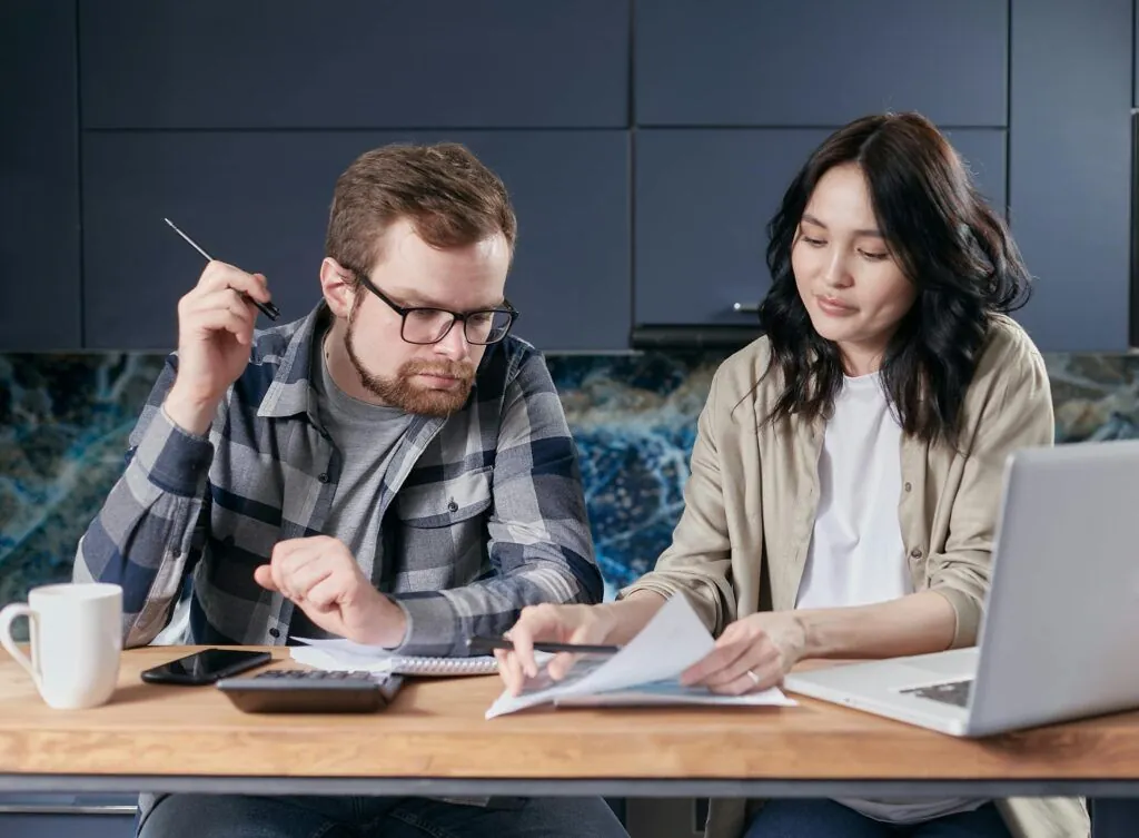 Couple sitting at a table reviewing paperwork together