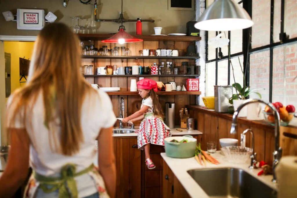 Mother and young daughter at home in the kitchen